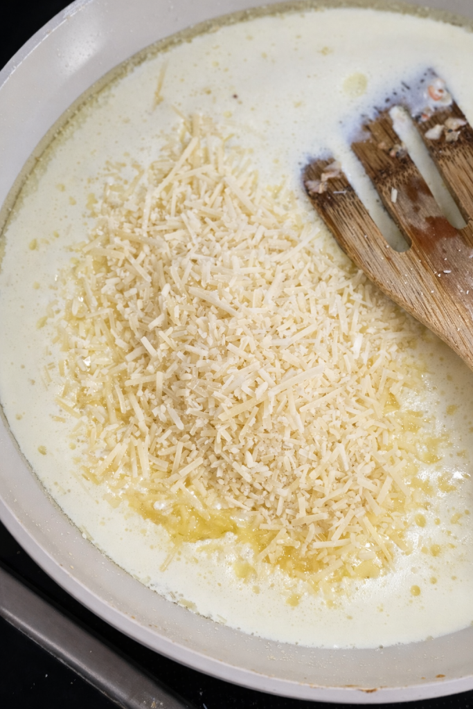 Pour in the heavy cream and slowly add the Parmesan cheese, stirring constantly